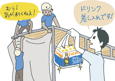 一生懸命イベントの設営をしている取引先に、栄養ドリンクの手土産を持参した若手。取引先に「気が利くねぇ！」と喜ばれている。