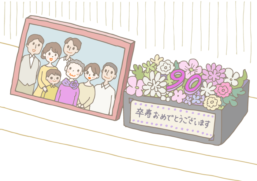 イラスト：棚に飾られた写真立てに入った家族で撮った卒寿祝いの日の記念写真と、ボックス入りの卒寿祝いプリザーブドフラワー