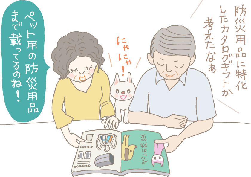 イラスト:防災用品カタログギフトをもらった初老の夫婦。「防災用品に特化したカタログギフトか、考えたなあ」という夫と「ペット用の防災用品まで載っているのね!」と嬉しそうな妻。二人の間には身を乗り出してカタログを見て「にゃにゃ!」と主張する猫ちゃんが。