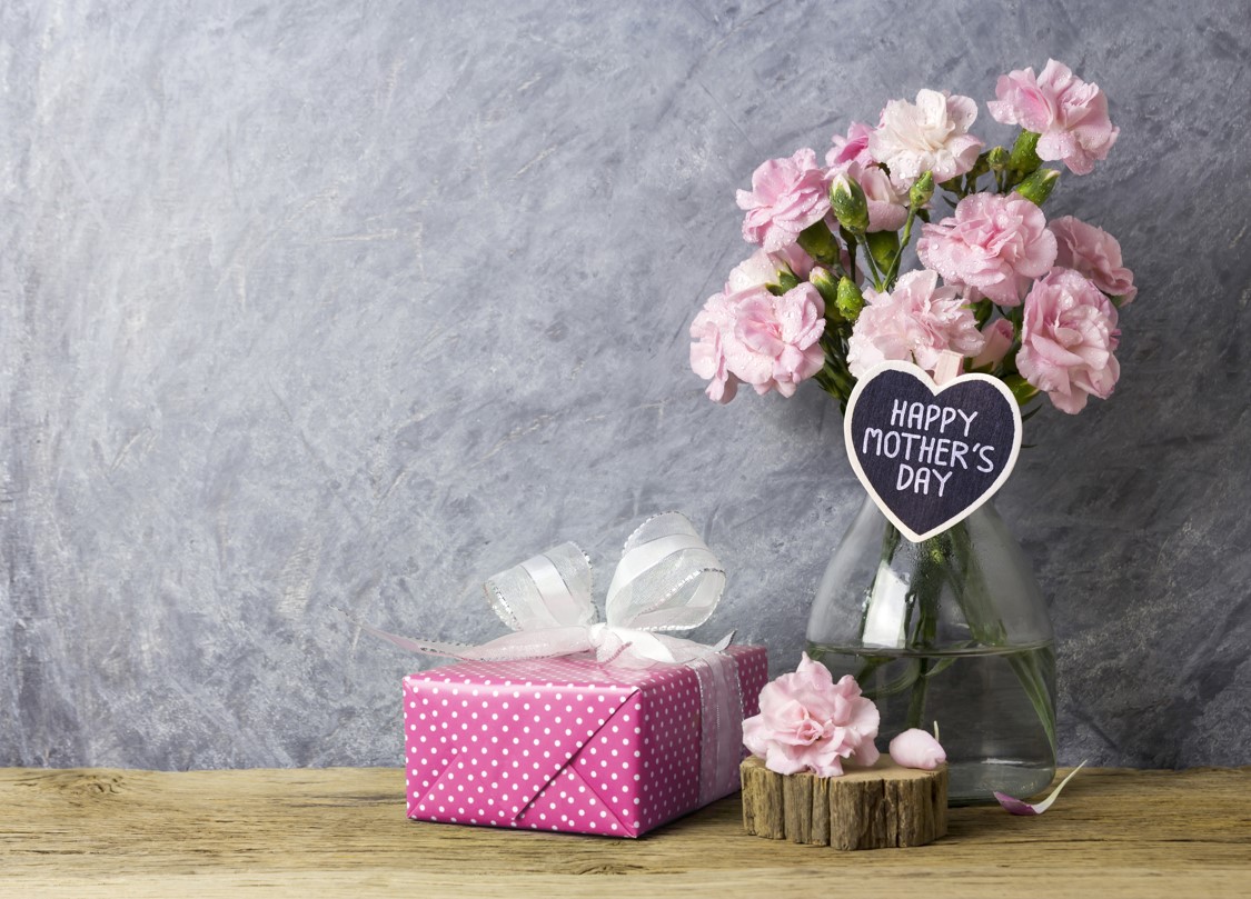 ハートウッドとピンクのギフトボックスに幸せな母の日の文字が付いた、瓶に入ったピンクのカーネーションの花